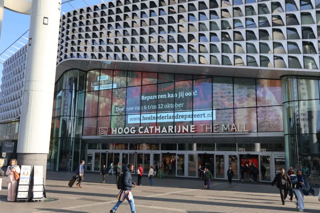 De gevel van het winkelcentrum Hoog Catharijne met campagnebeeld van Heel Nederland Repareert op een groot beeldscherm.