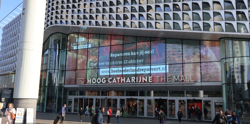 De gevel van het winkelcentrum Hoog Catharijne met campagnebeeld van Heel Nederland Repareert op een groot beeldscherm.